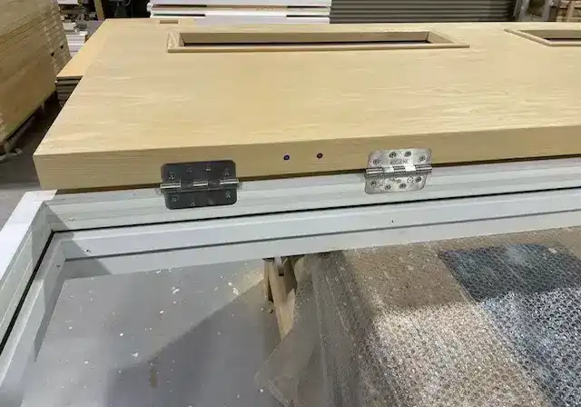 Close-up of two steel hinges on a fire door