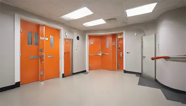 Orange fire doors with vision panels installed in Newcastle hospital corridor